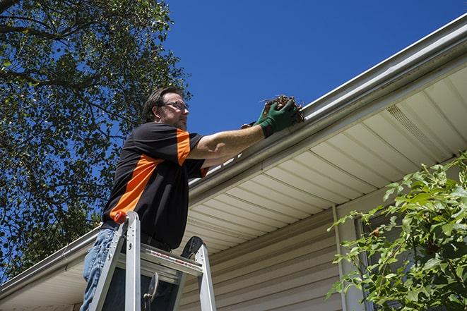 maintenance worker replacing a damaged gutter in Coarsegold